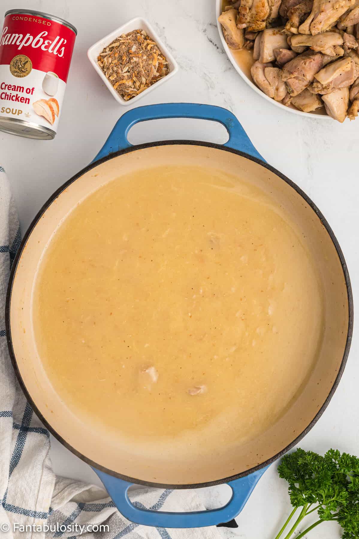 A creamy chicken gravy is shown in a large pan