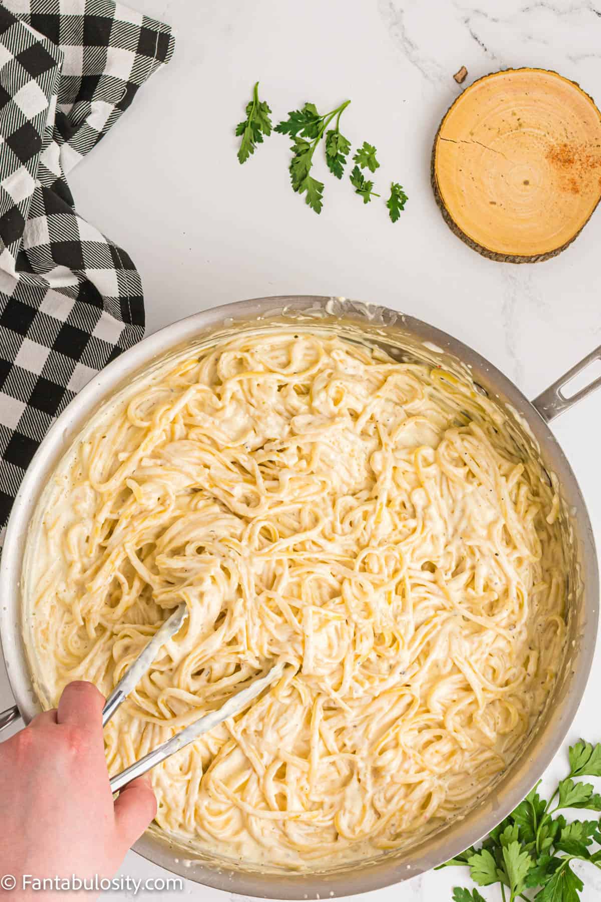 Cream cheese pasta in a pot being stirred together.