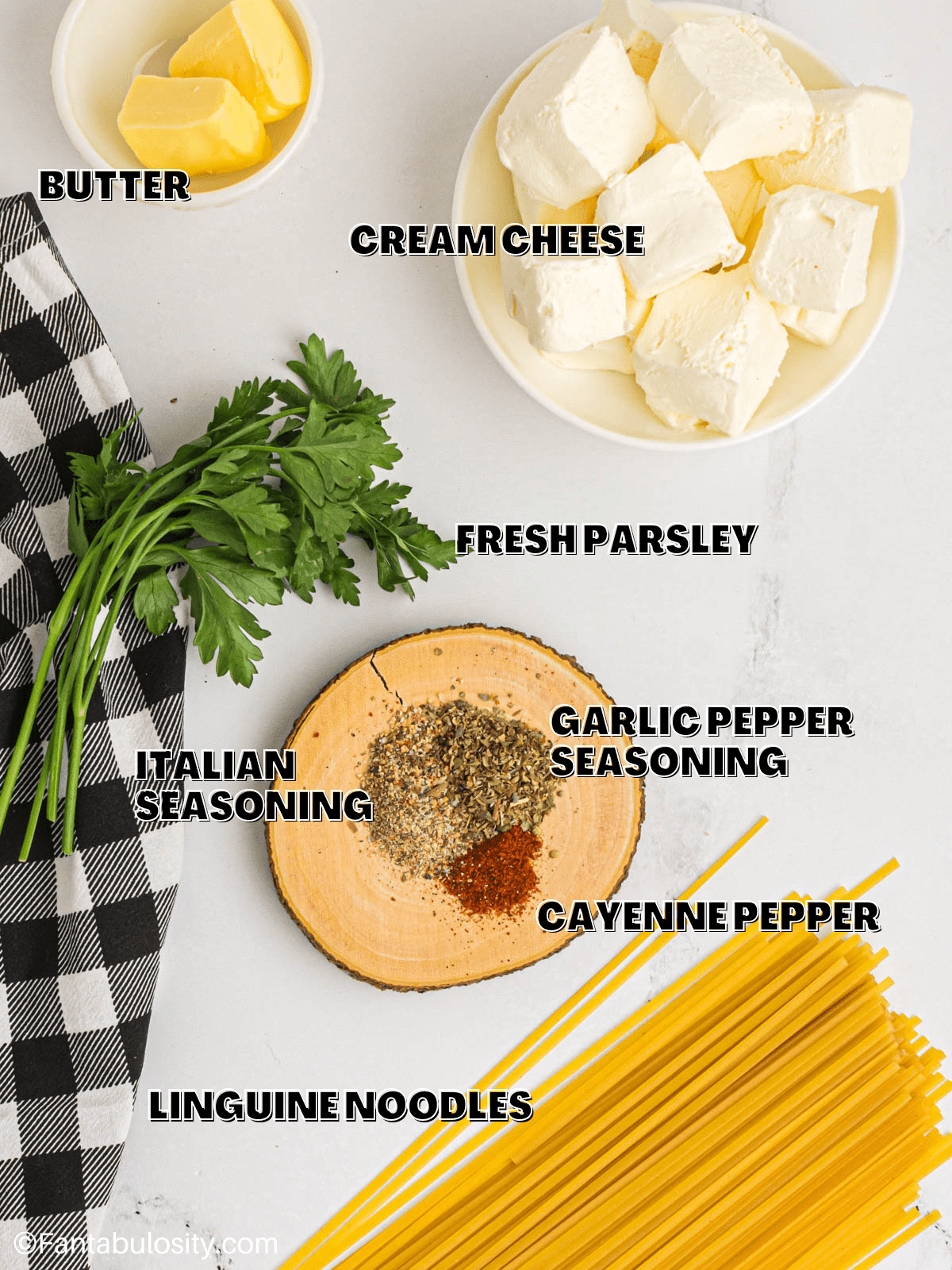 The ingredients for cream cheese pasta laid out on a counter with labels on the image. 