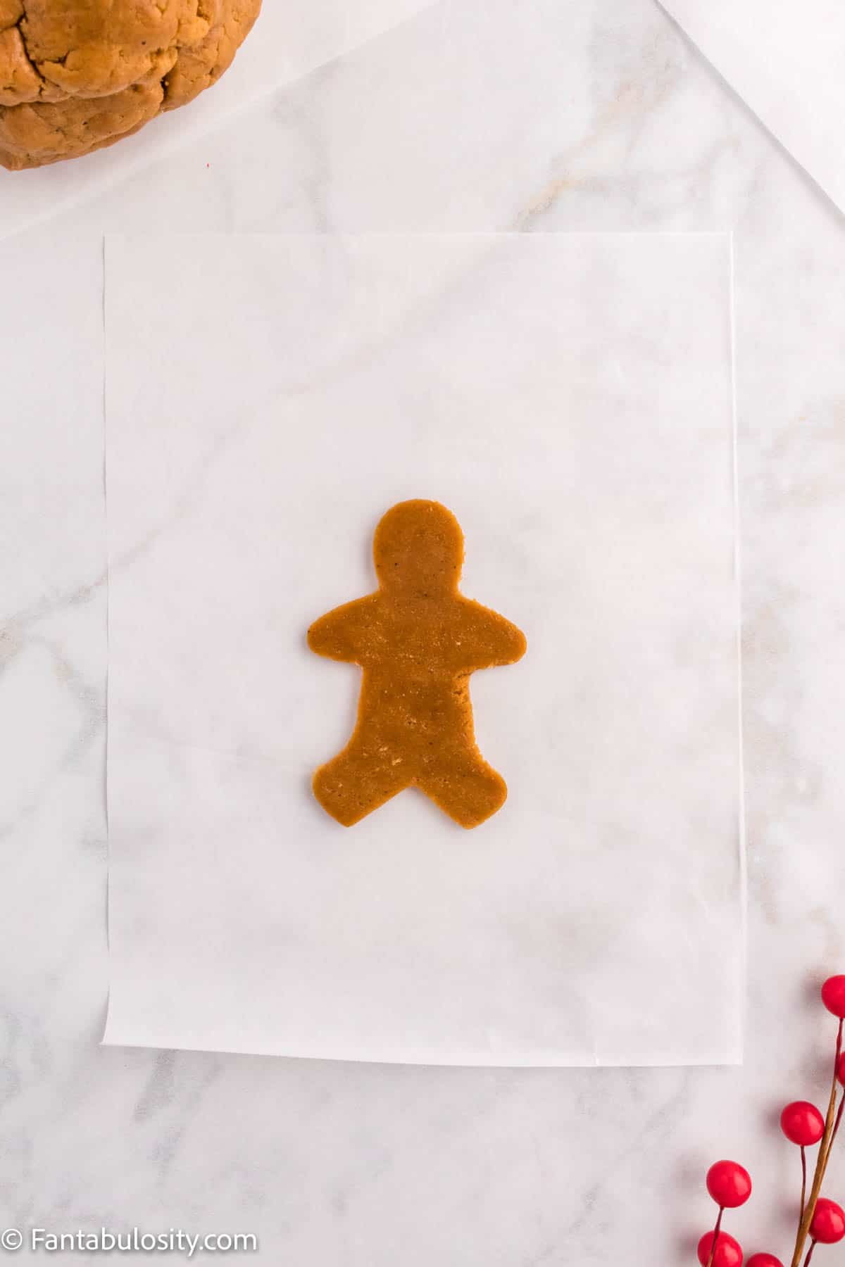 Deep brown cookie dough has been cut into the shape of a gingerbread man