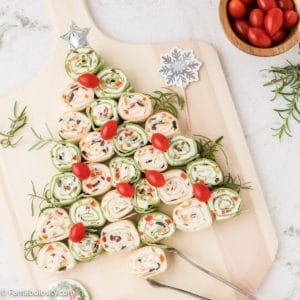 Savory pinwheel slices are arranged to look like a Christmas tree on a wooden serving board