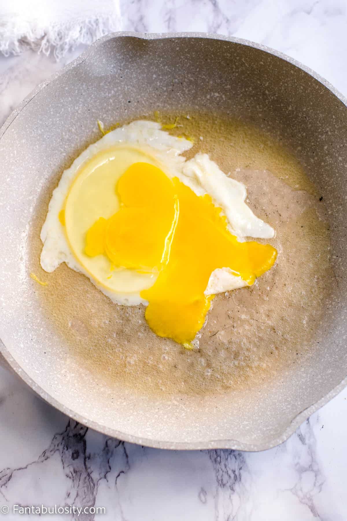 Cracked egg in skillet
