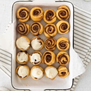 20 mini cinnamon rolls in a 9x13 baking dish, 7 of them with frosting on top.