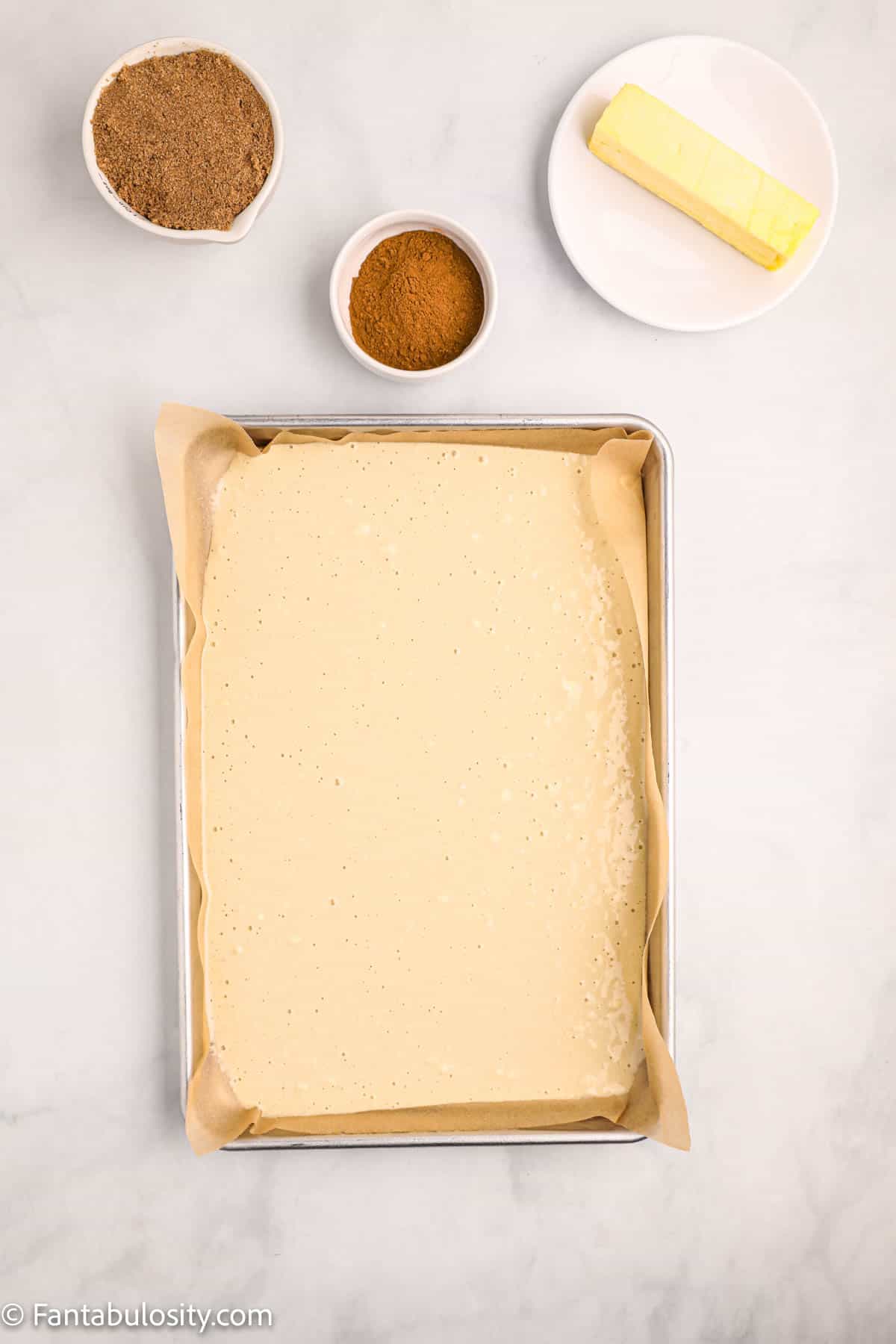 Pancake batter has been poured into a prepared sheet pan for sheet pan pancakes
