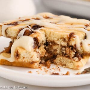 A close up photo of a stack of cinnamon swirled pancake squares that were baked on a sheet pan