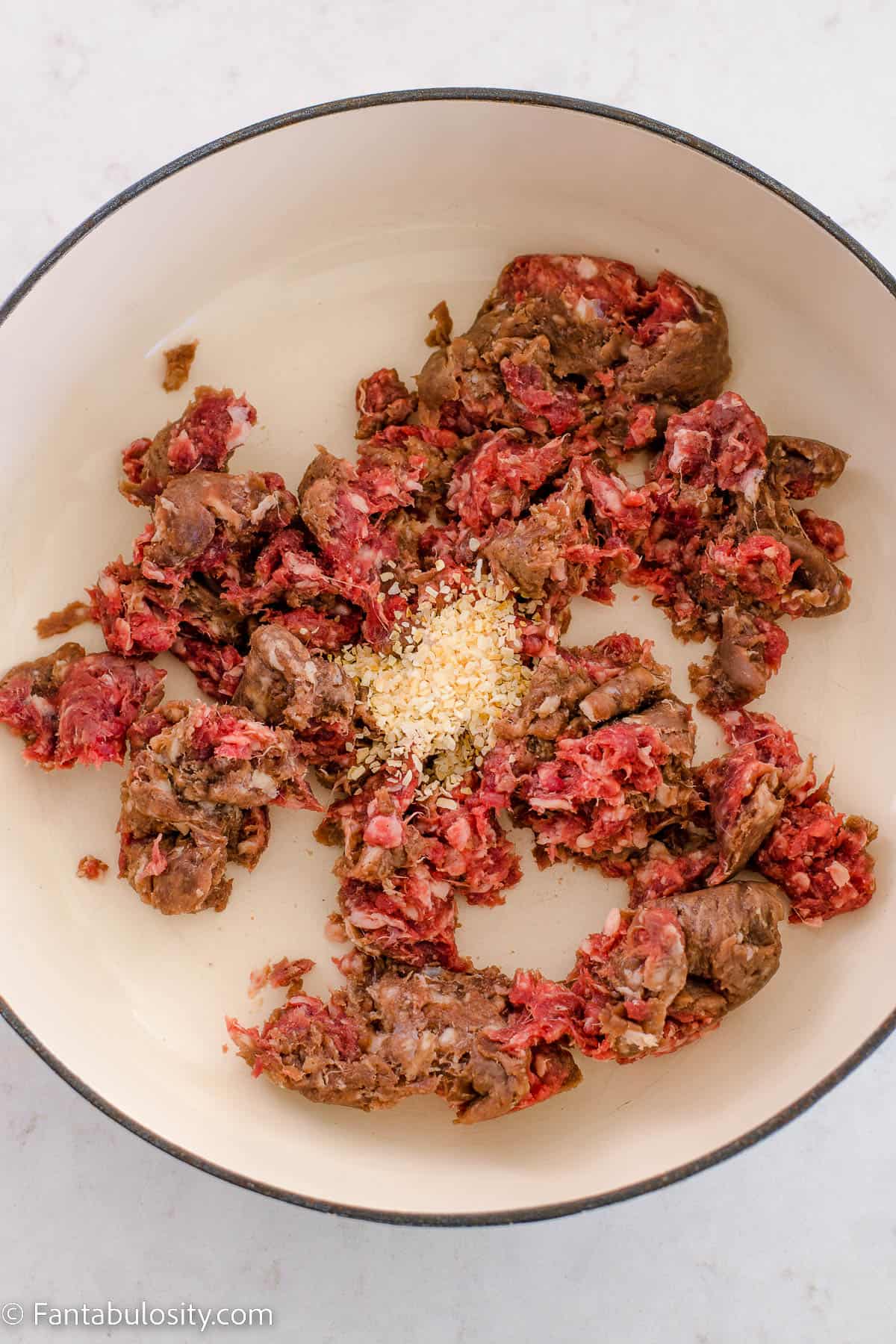 ground venison and onion in white cast iron