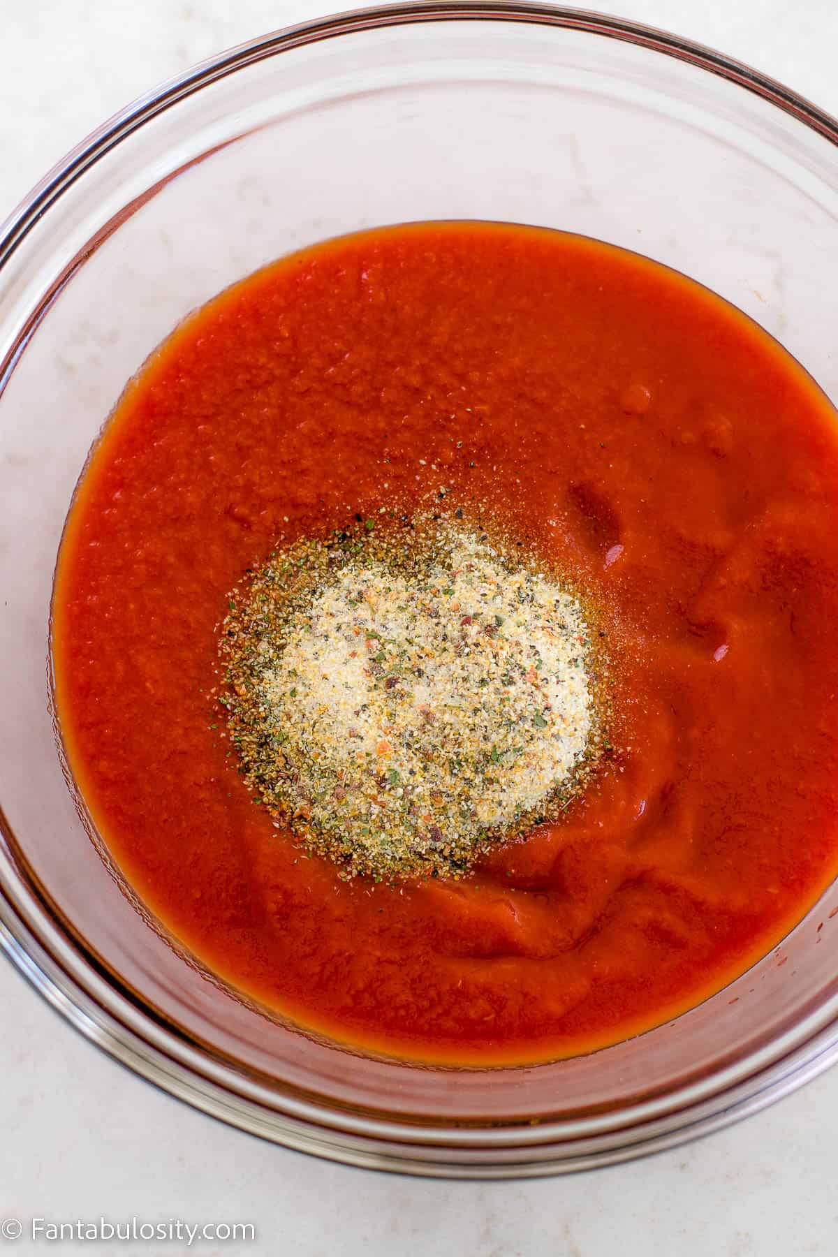 tomato sauce in bowl with Italian dressing seasoning