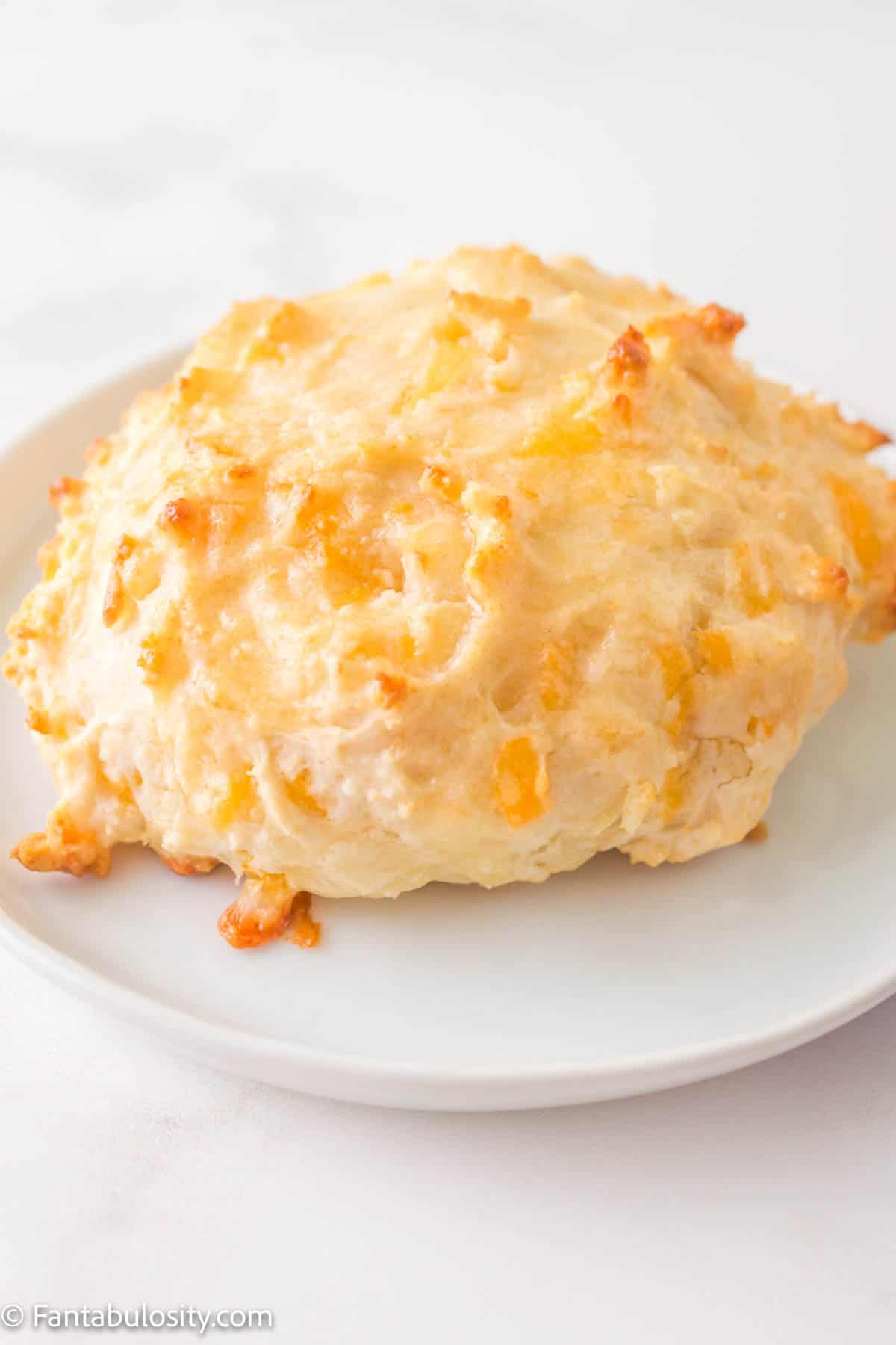 A Bisquick cheddar biscuit on a plate. 