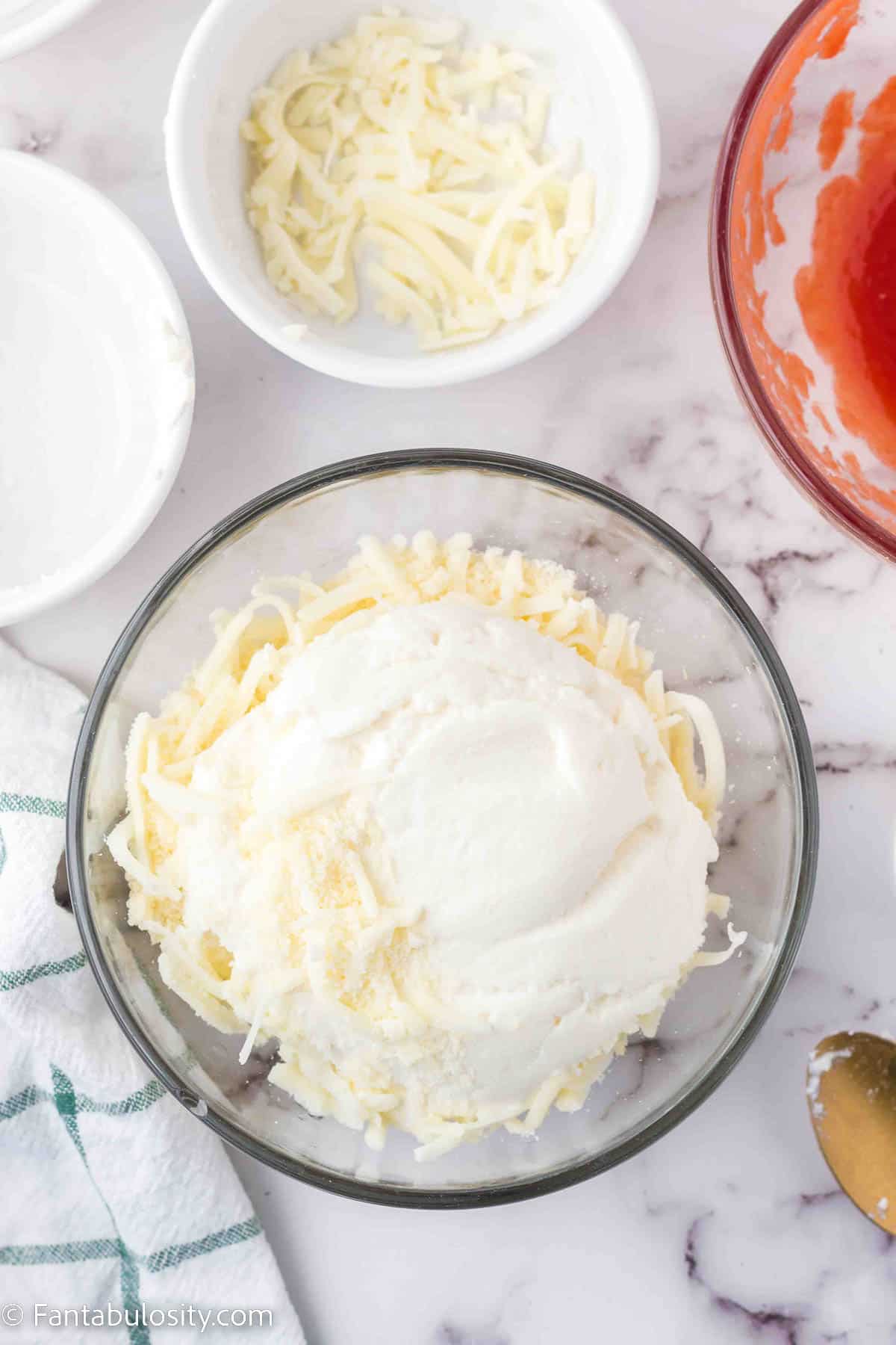 Ricotta and cheeses in mixing bowl.