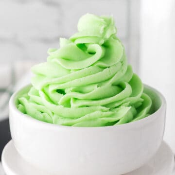 Mint buttercream swirled in to small white dish.