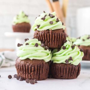 3 mint chocolate cupcakes stacked on top of one another.