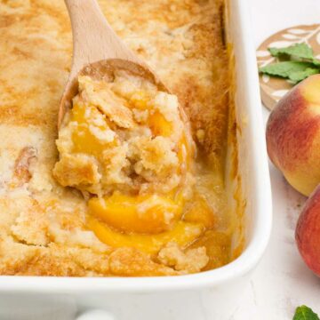 Peach cobbler that was made with cake mix in a white baking pan.