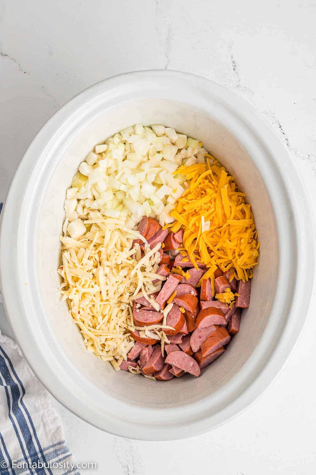 Ingredients in slow cooker for sausage and potato casserole.