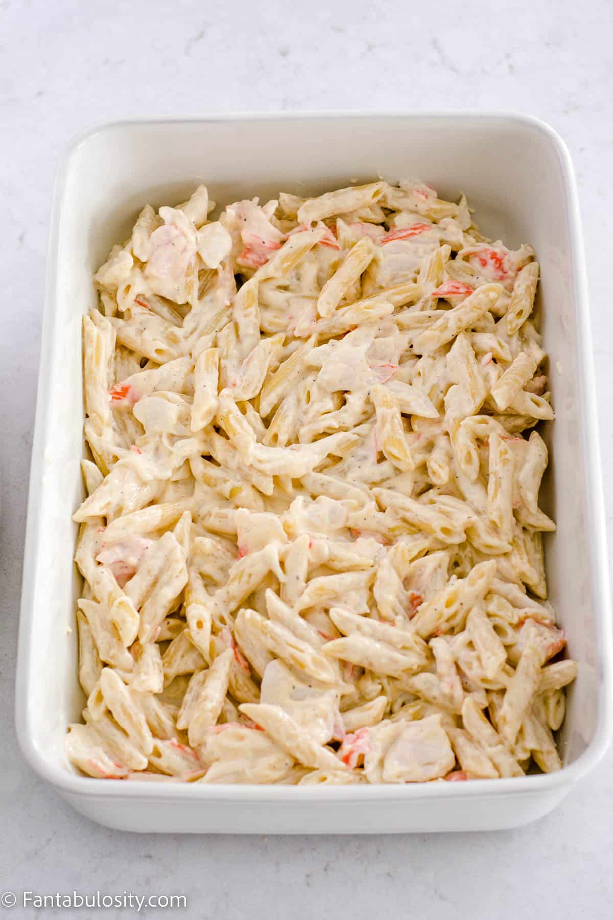 Half of the pasta and crab mixture poured in to baking dish.