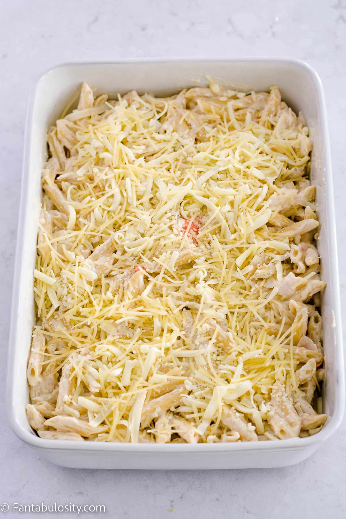 Mozzarella and shredded parmesan spread out on top of the crab casserole.