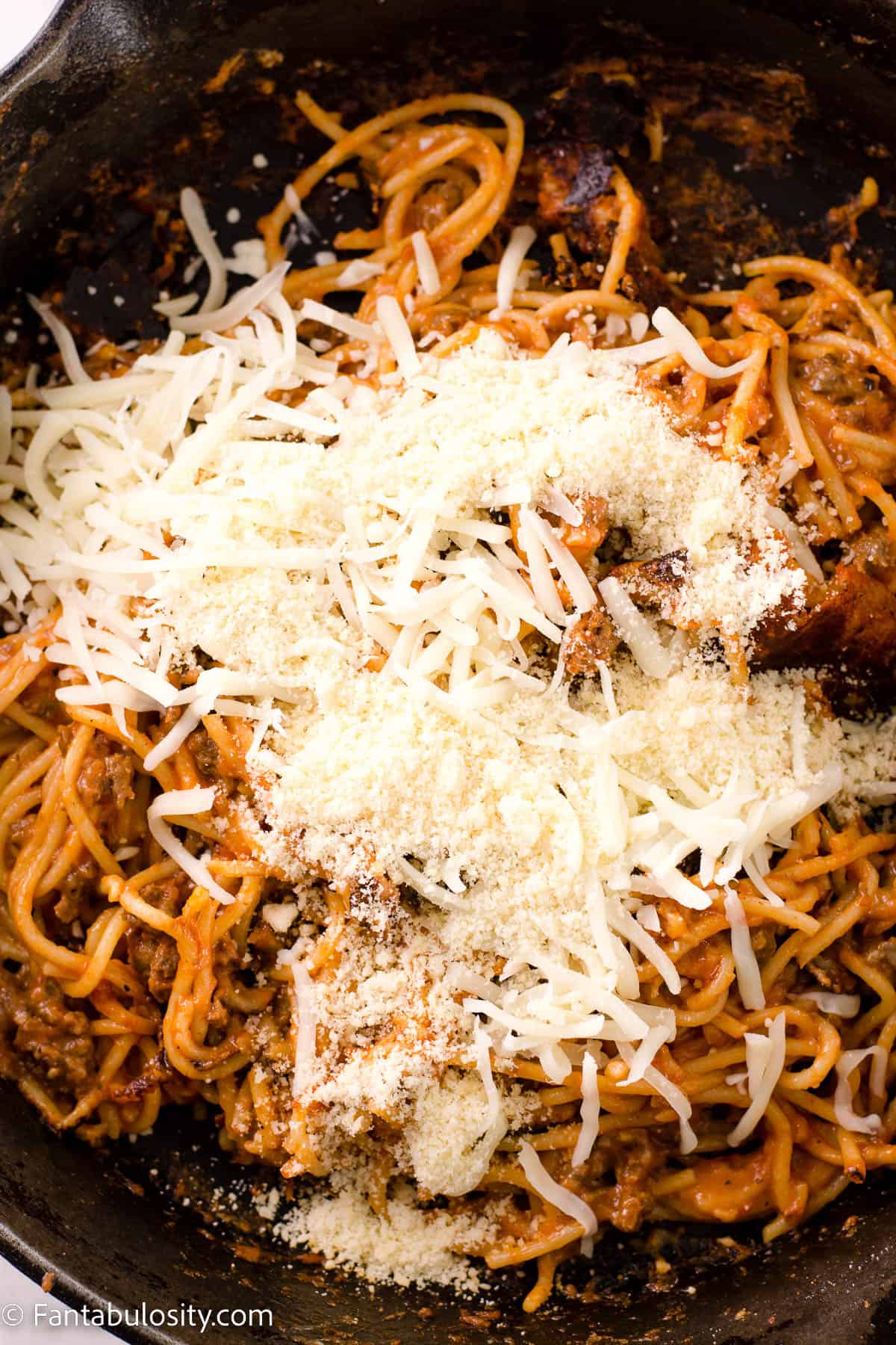 The rest of the mozzarella and parmesan cheese sprinkled on top of spaghetti.