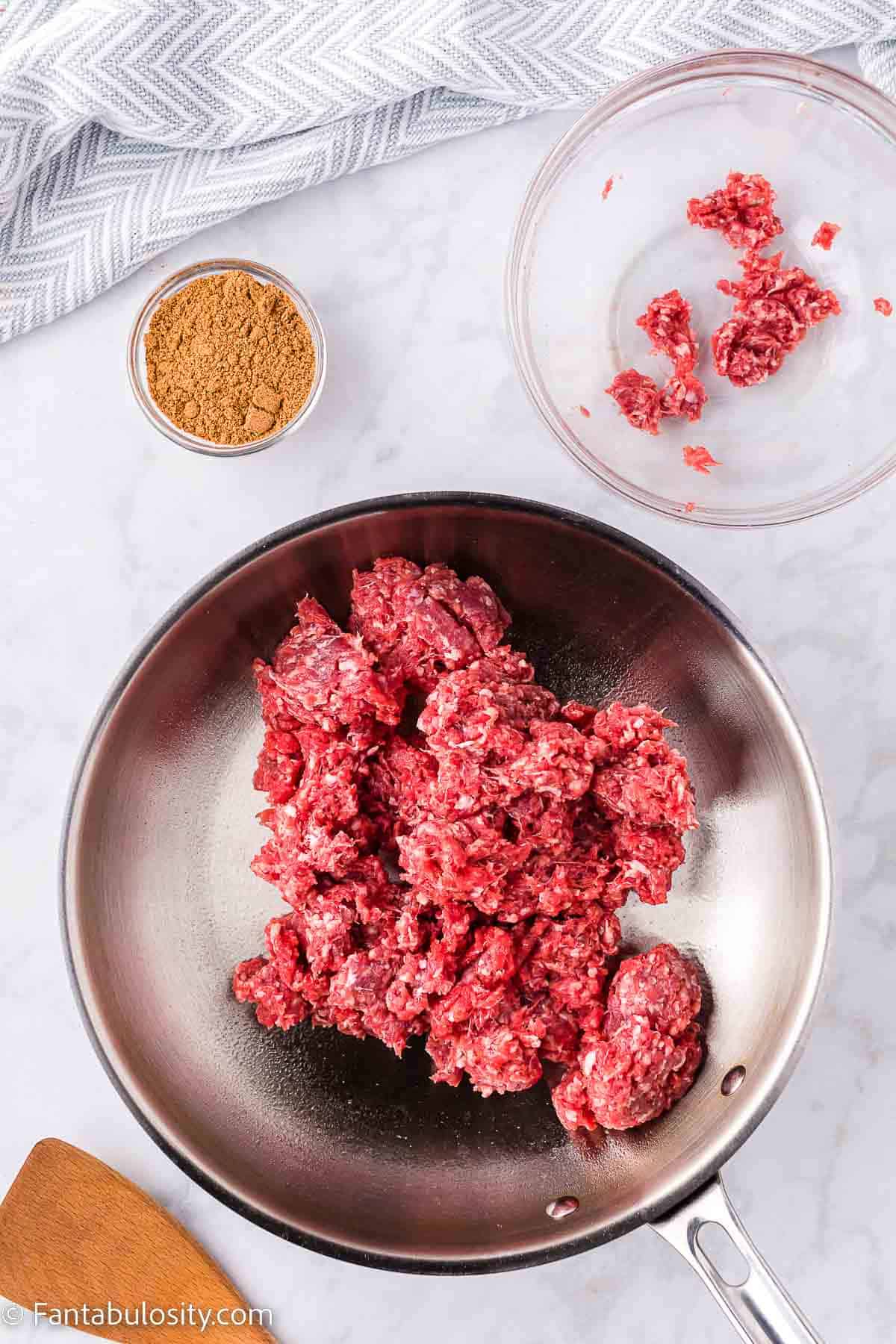 Raw ground beef in skillet.