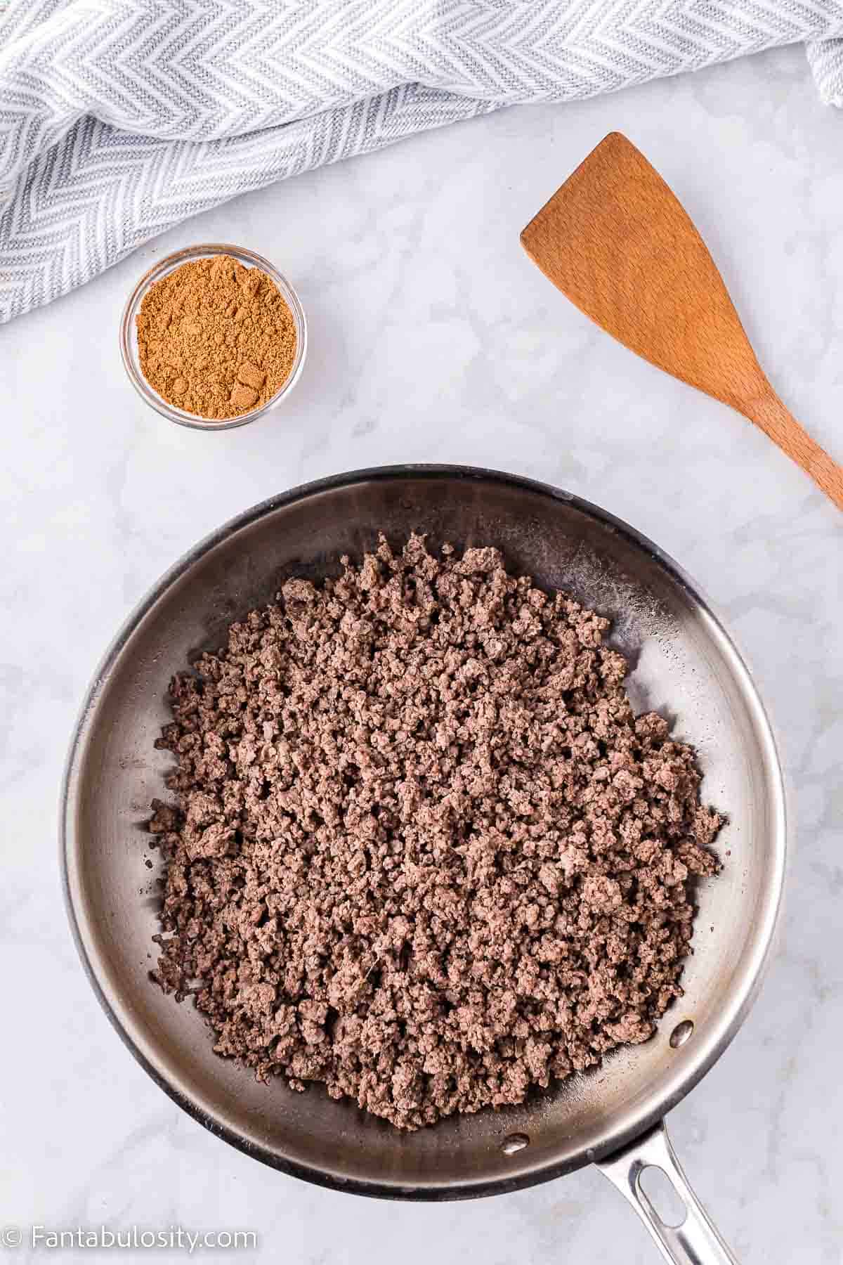 Cooked ground beef in skillet.