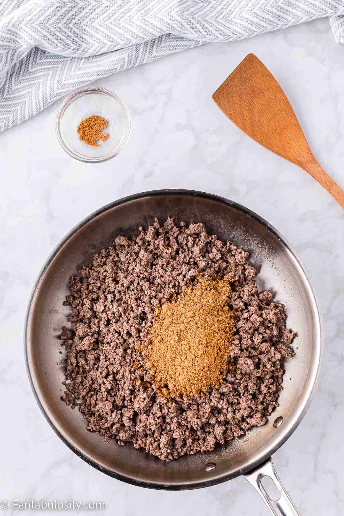 Taco seasoning in skillet on top of cooked ground beef.