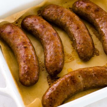 Baked Italian sausages in baking dish.