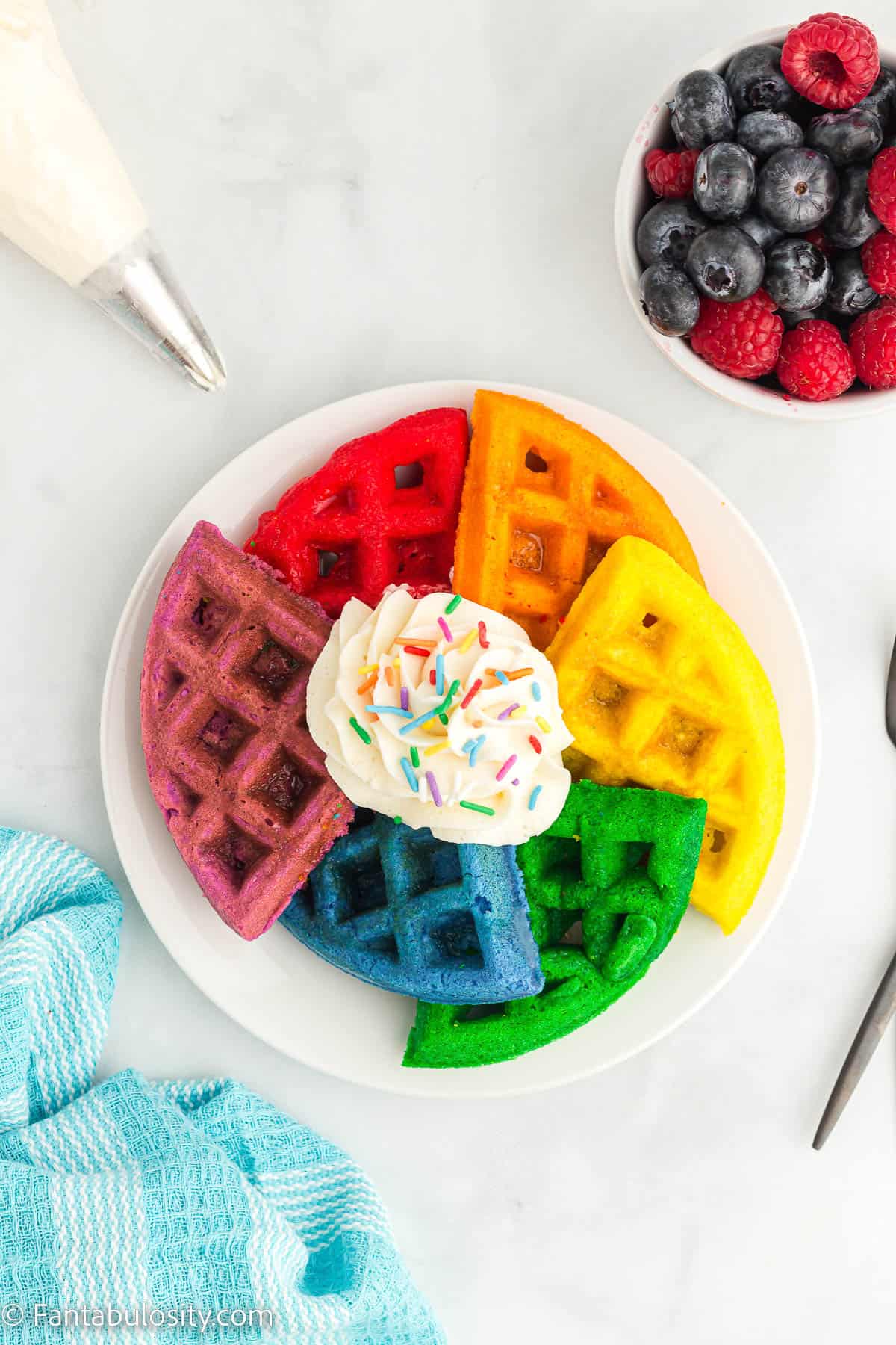 Rainbow waffles arranged in a circle on a white plate. 