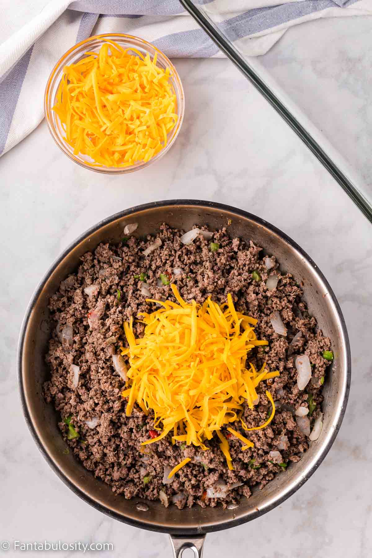 Shredded cheddar on top of browned ground beef.