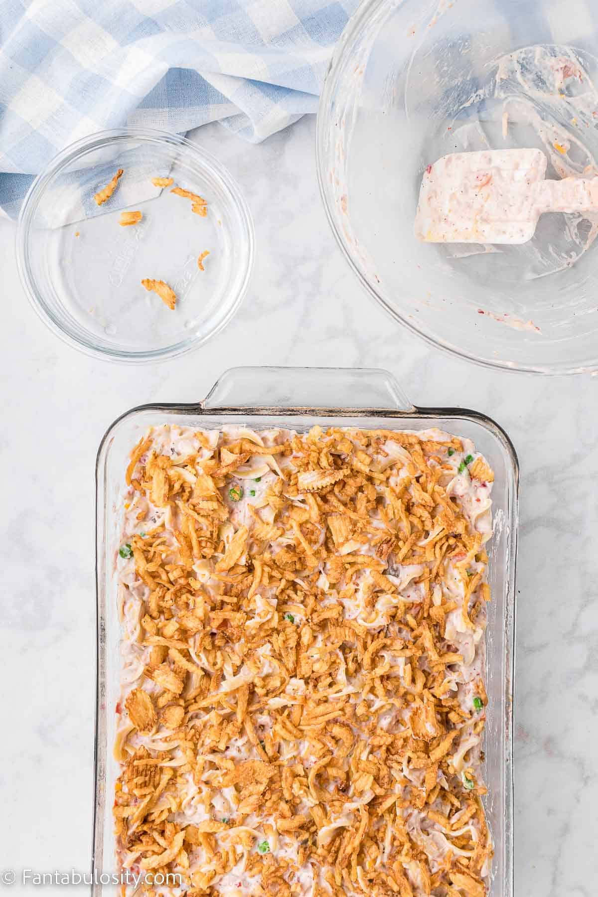 French fried onions sprinkled on top of tuna casserole in baking dish.