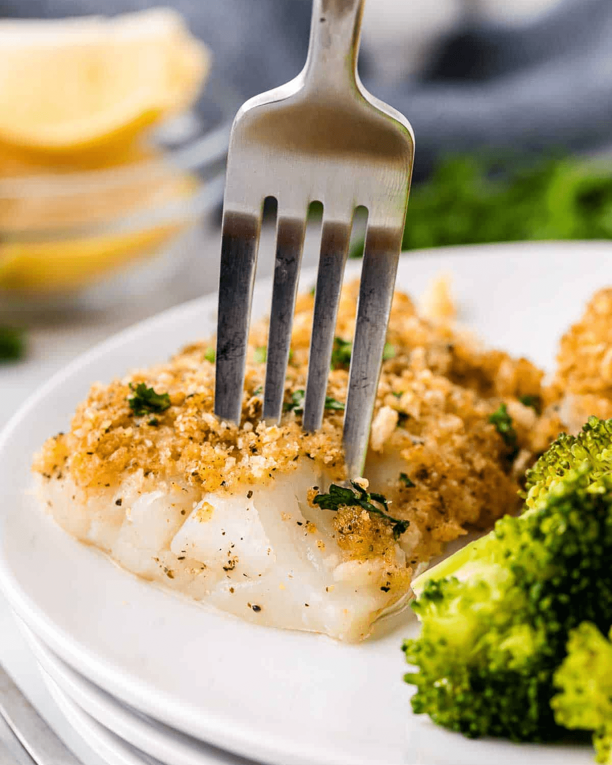 Panko crusted cod with a fork and broccoli on a plate 