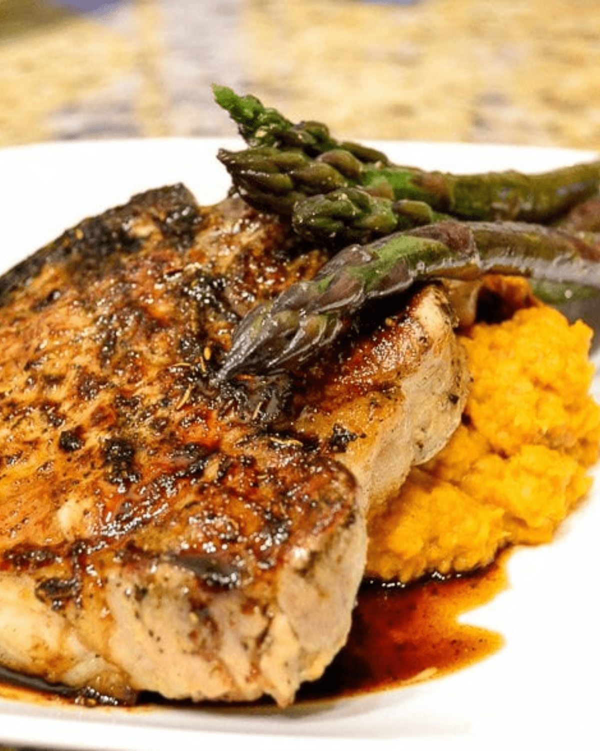 Juicy grilled pork chops with asparagus on a white plate