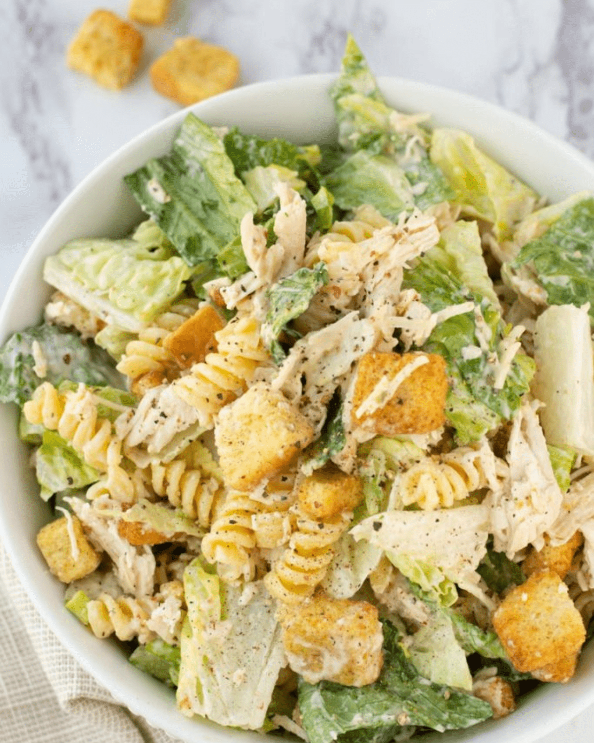 Chicken caesar salad with pasta in a bowl