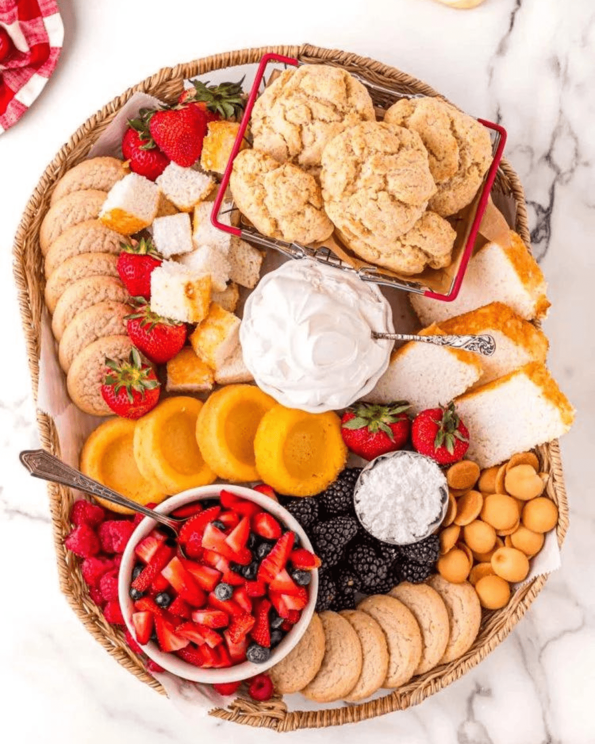 shortcake characuterie with berries, cookies and whipped cream on a board