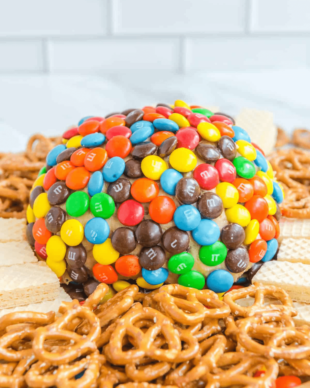 M&M candy coated peanut butter cream cheese ball with pretzels