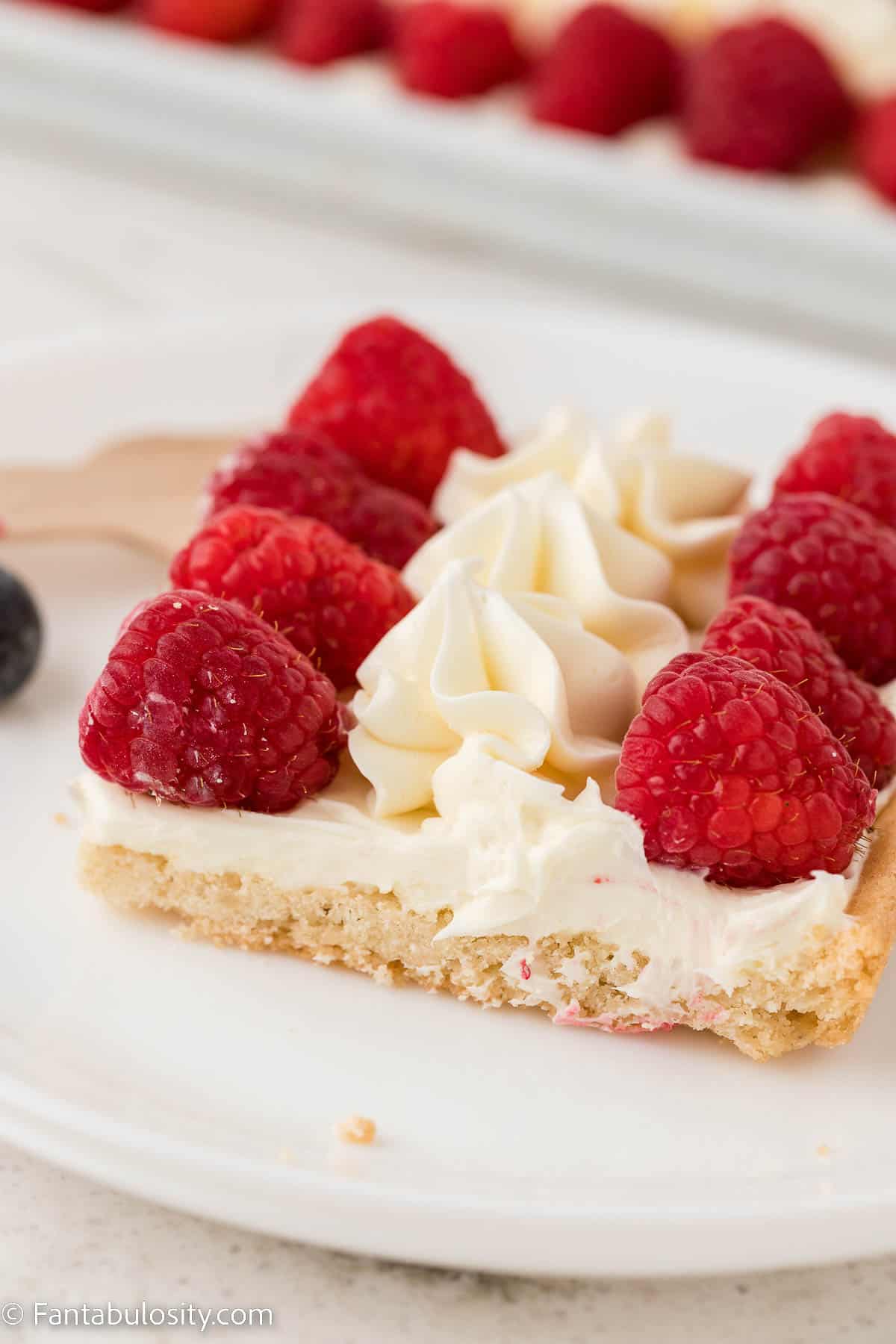 Slice of 4th of July fruit pizza on white plate.