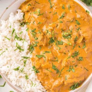 Butter Chicken next to white rice in large serving bowl.