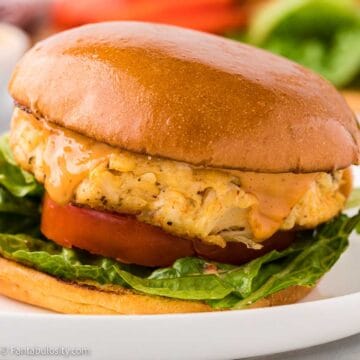 Crab cake sandwich on white plate.