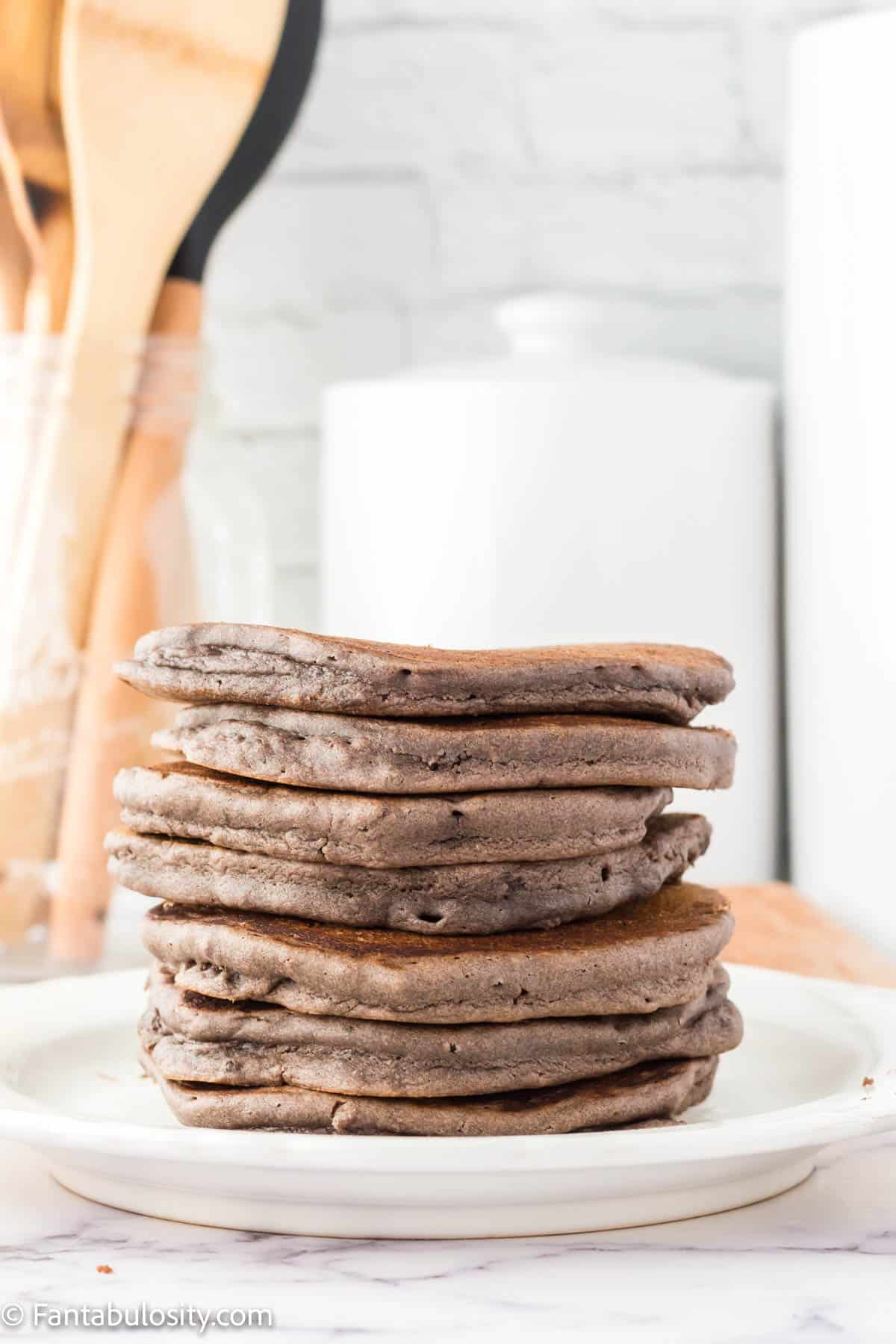 Stacked Oreo pancakes on white plate.