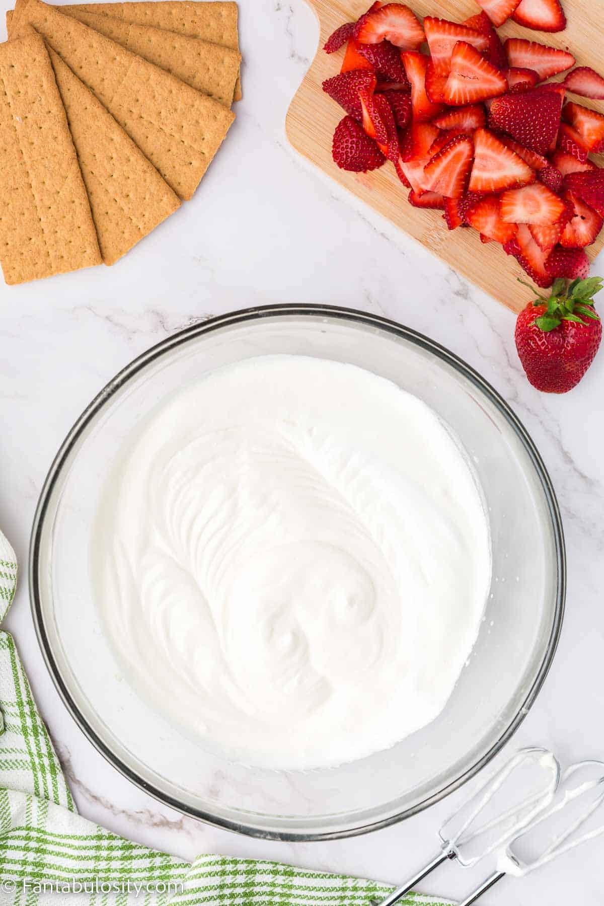 Mixed pudding, cream cheese and cool whip in mixing bowl.