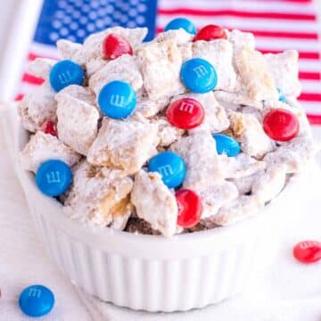 4th of July Puppy Chow in white bowl, next to American Flag.