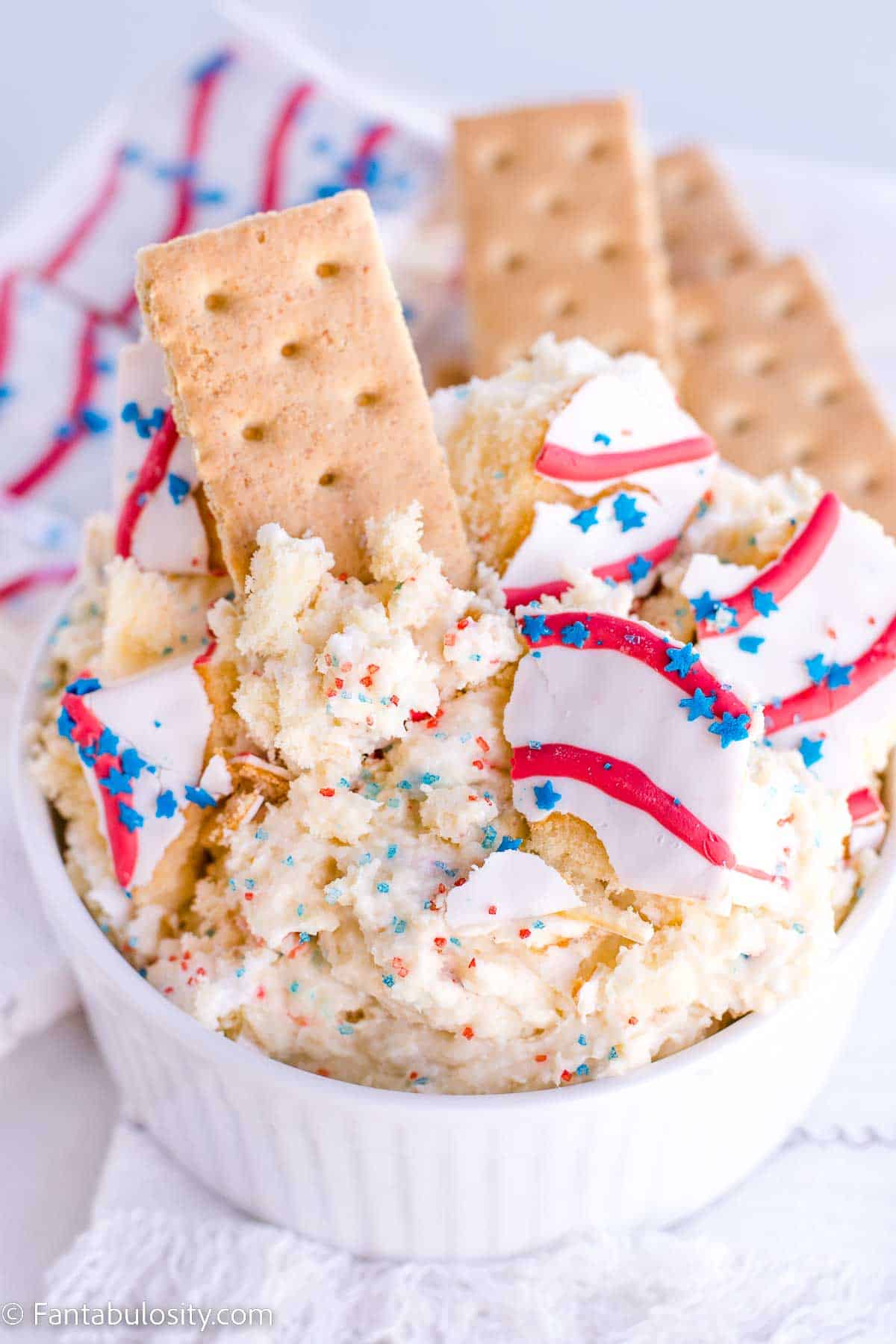 Red white and blue dip in white bowl, with snack cakes on top.