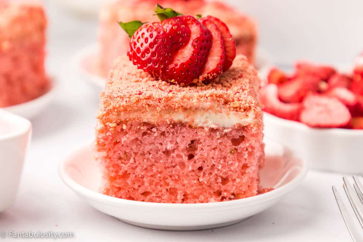 Slice of strawberry crunch cake on white plate.