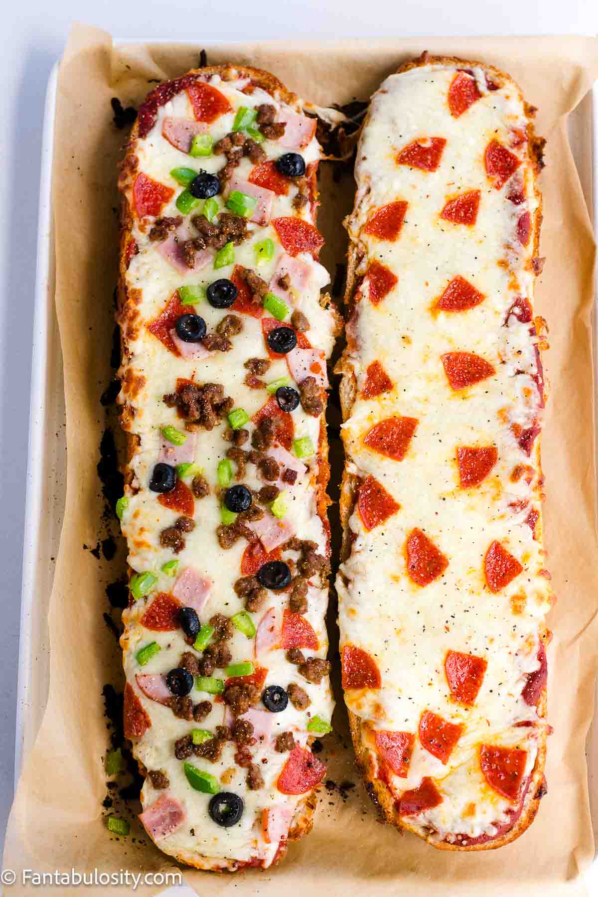 Two pieces of french bread pizza on baking sheet.