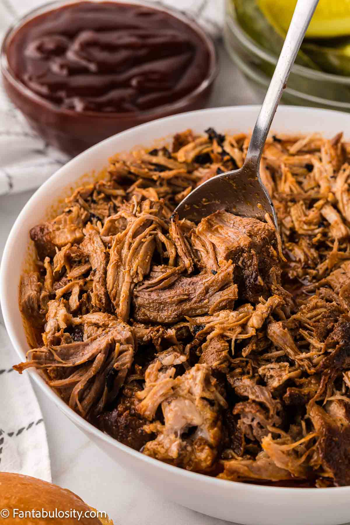 Cooked Instant Pot pork butt in white bowl.