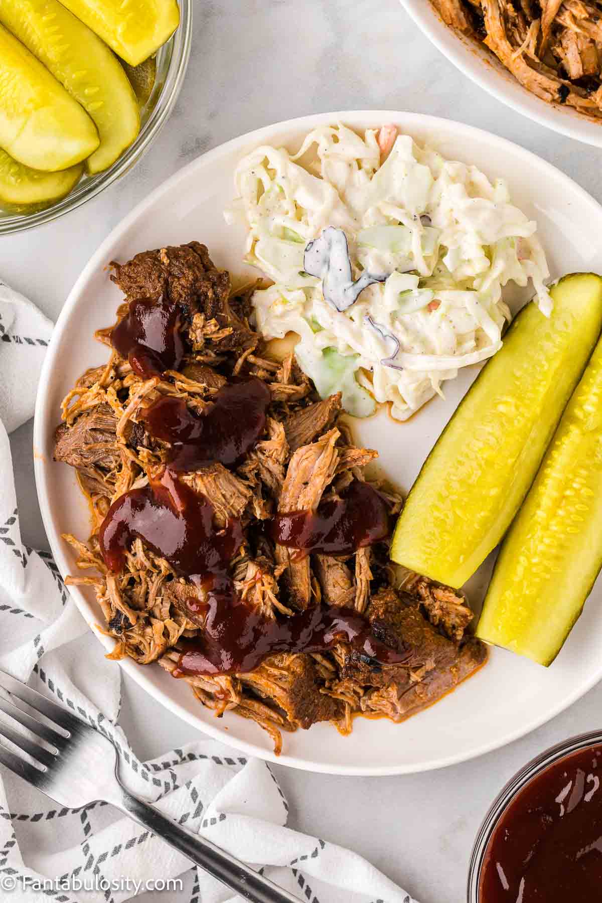 Instant Pot pork butt, shredded, on white plate.