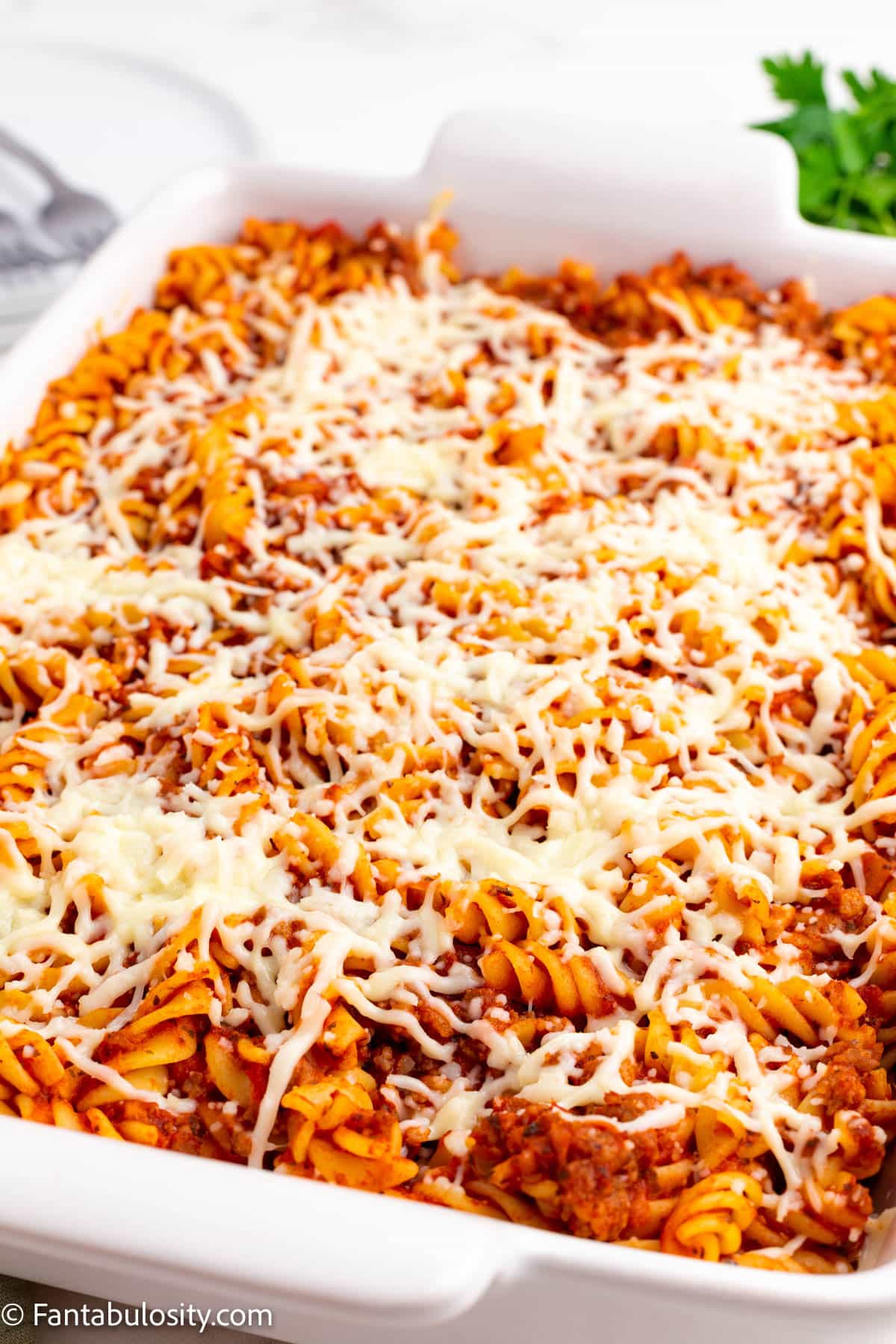 Baked sausage pasta bake in white baking dish.