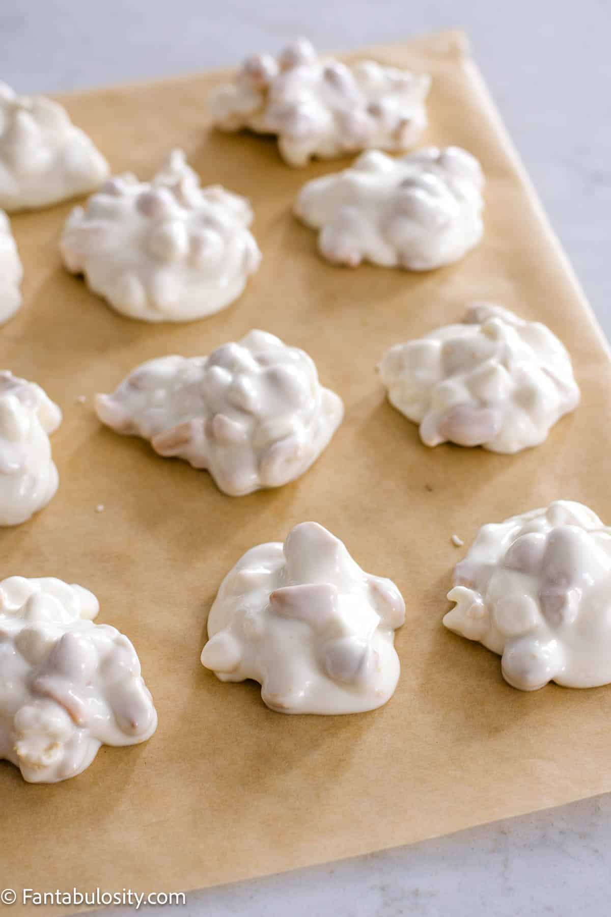 White chocolate crock pot candy on parchment paper to dry.