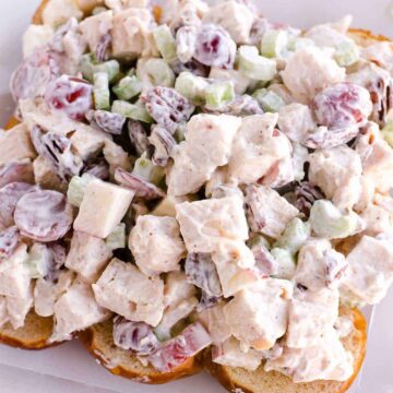 Chicken salad with grapes and apples, sitting on bread.