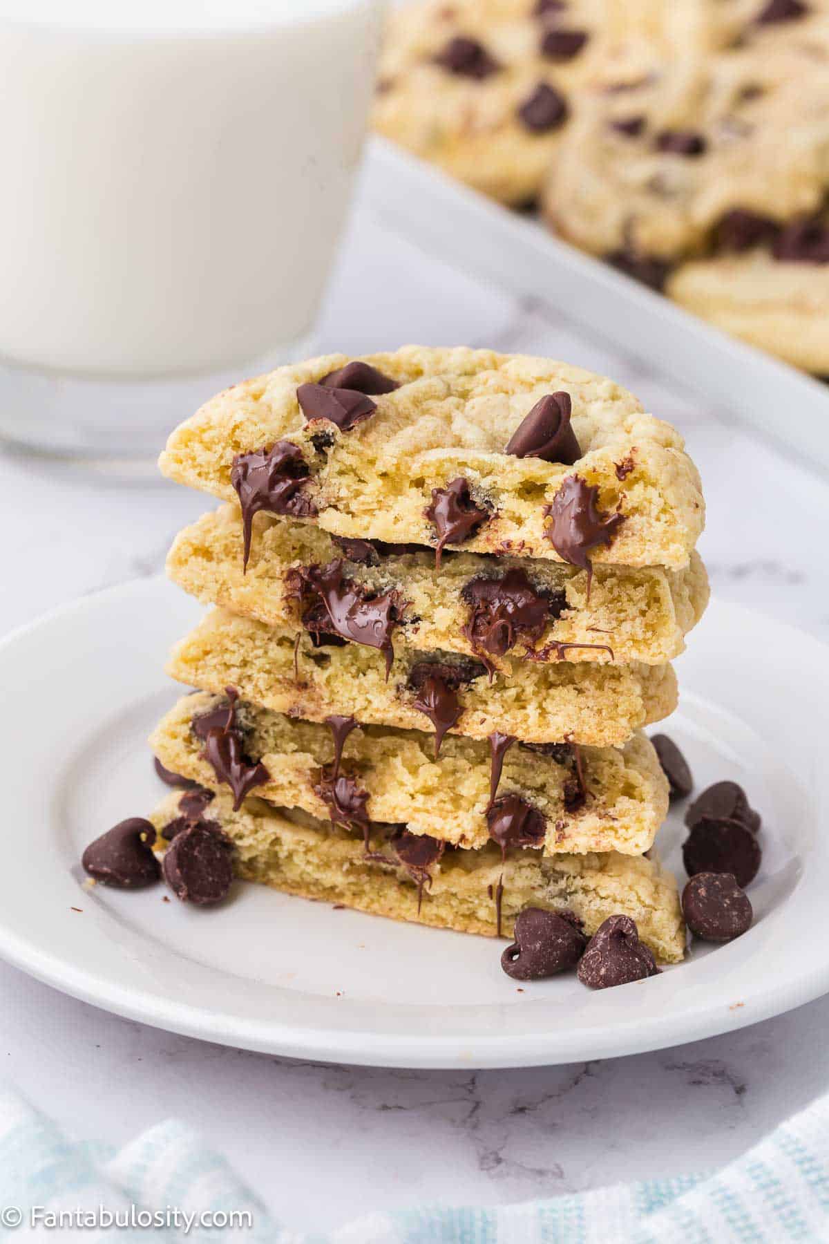 Stacked chocolate chip sugar cookies on a small white plate.