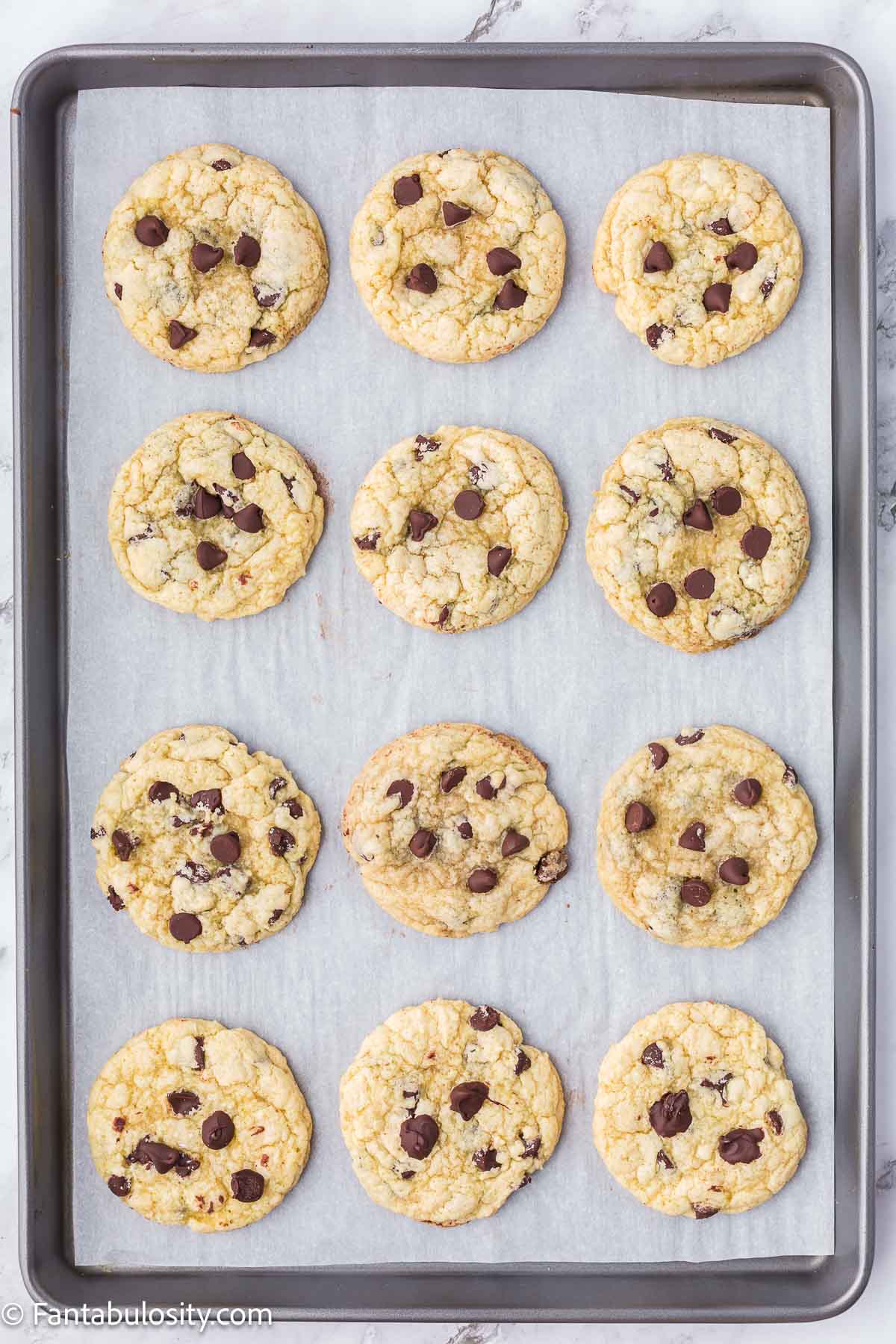 Baked chocolate chip sugar cookies on baking pan.