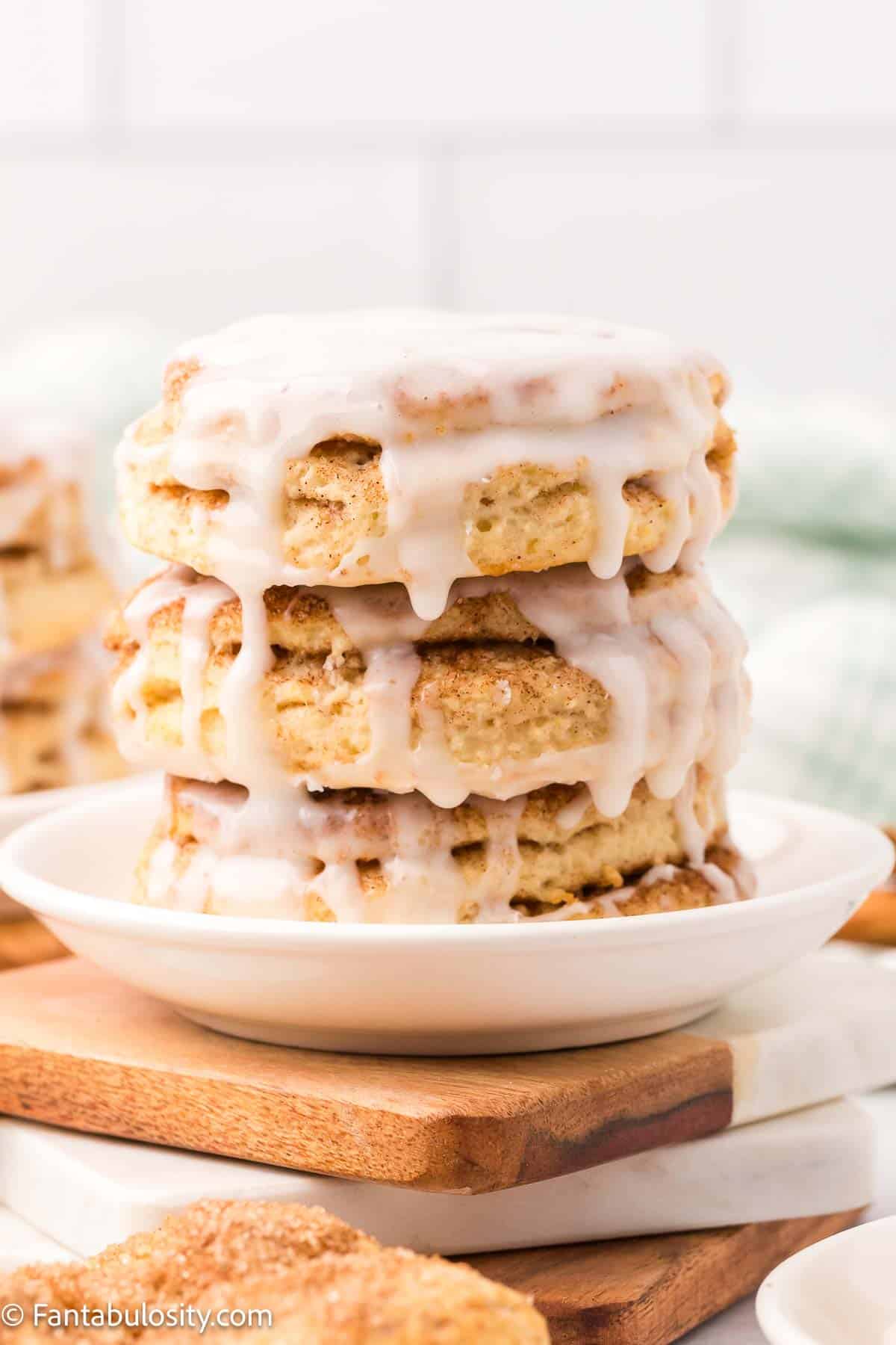 Stack of cinnamon biscuits on white plate.