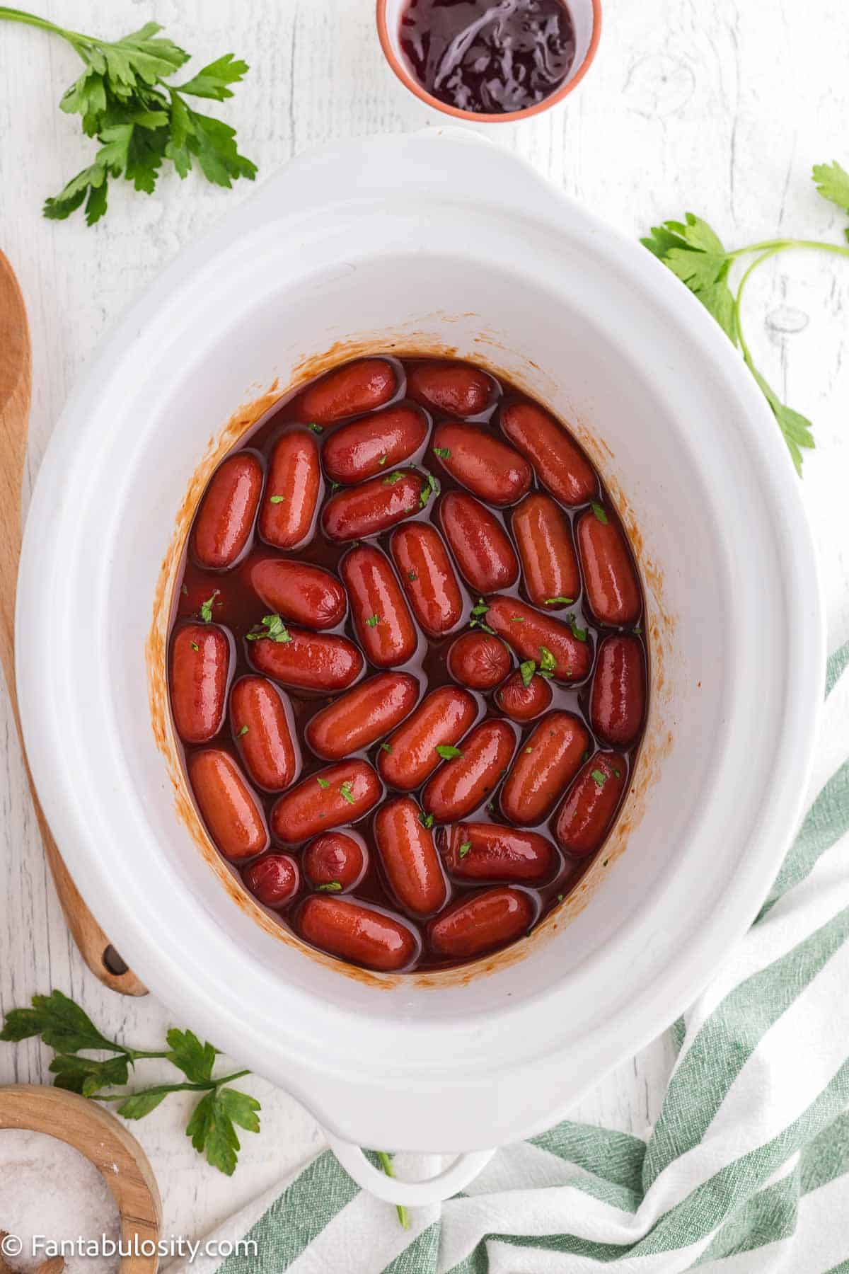 Cooked little smokies in white crockpot.